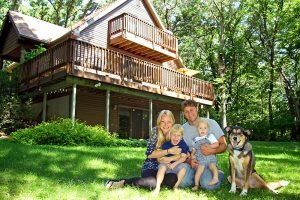 Dog with family in front of new home